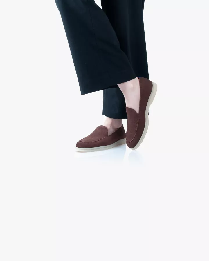Mocassins en daim marron portés jambes croisées